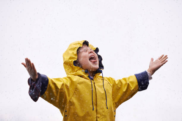 雨の中子供が手を広げている