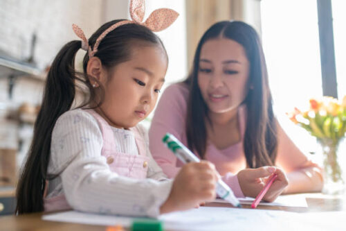 子供の勉強をお母さんが隣で見てあげている